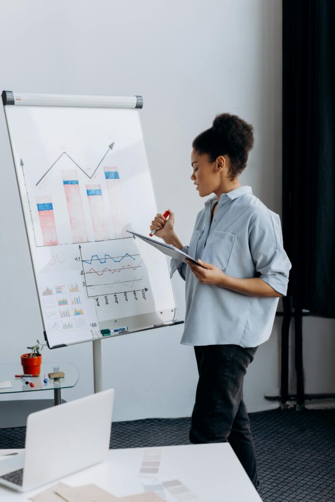 pexels-photo-6592676-6592676 Professional businesswoman presenting data analytics on a flipchart in a modern office.